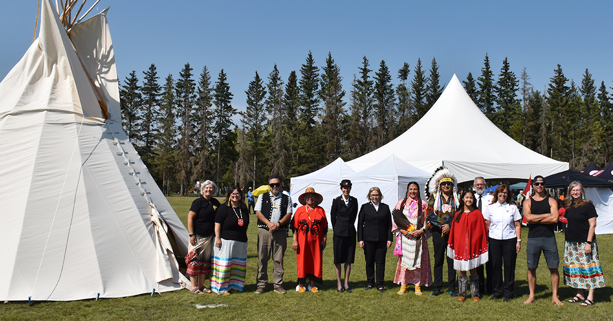 A group of people standing next to a tipi